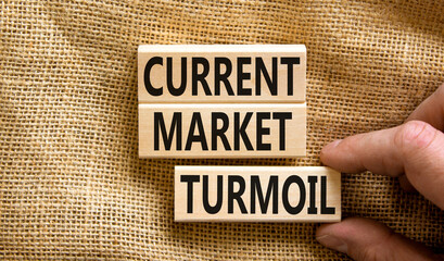 Current market turmoil symbol. Concept words Current market turmoil on wooden blocks on a beautiful canvas table canvas background. Businessman hand. Business, finacial current market turmoil concept.