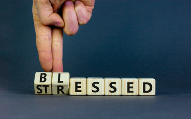 Blessed or stressed symbol. Businessman turns wooden cubes and changes the concept word Stressed to Blessed. Beautiful grey table grey background. Business blessed or stressed concept. Copy space.