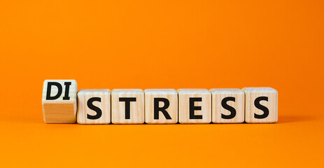 Distress or stress symbol. Turned the wooden cube and changed the concept word Distress to Stress. Beautiful orange table orange background, copy space. Psychlogical and stress or distress concept.