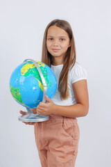 girl stands and holds a globe in the studio