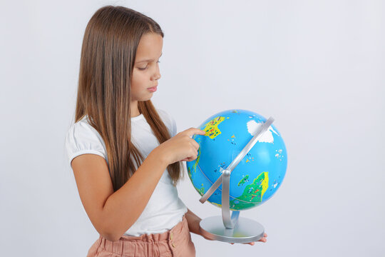 girl looks and points her finger at the globe. High quality photo
