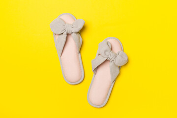 Soft pink slippers on color background, top view