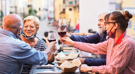 Group of old people eating and drinking outdoor - Doubble date with facemask on - Focusing glasses