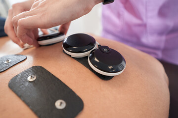 Fototapeta premium Male patient receiving myostimulation treatment in clinic
