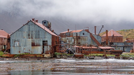 Fototapeta premium Rusted remains of a whaling station at Leith Harbor, South Georgia Island, under overcast skies
