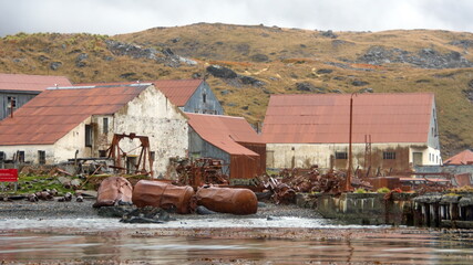 Old tanks in the rusted remains of a whaling station at Leith Harbor, South Georgia Island, under overcast skies