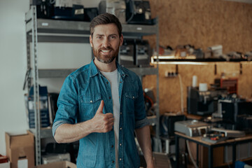 Obraz premium Business owner standing on workshop of coffee machines warehouse with rise finger up