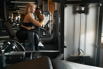 Fototapeta na wymiar Fit lady doing leg workout in fitness studio