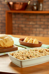 Shredded chicken platter with chicken croquettes on a wooden table.