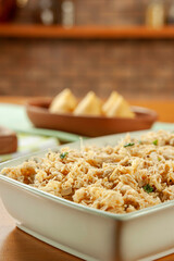 Shredded chicken platter with chicken croquettes on a wooden table.