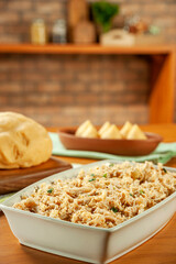 Shredded chicken platter with chicken croquettes on a wooden table.