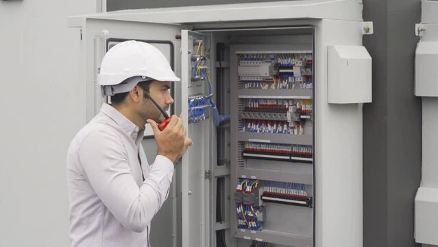 An engineer man or worker, people working in electrical room. Power energy motor machinery cabinets with panel in control or server room, operator station network in industry factory. Switchgear