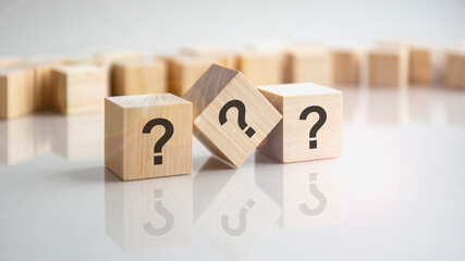 question mark shown on three wooden cubes on a grey background