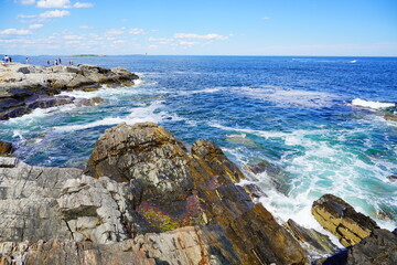 Atlantic ocean waves and rock beach along coastline in Portland, Maine, USA