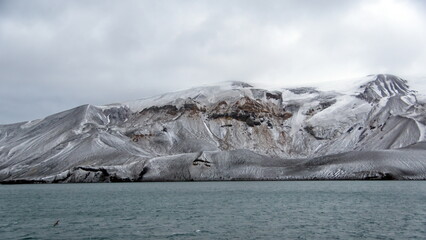 Snow dusted mountains above the crater bay in Deception Island, Antarctica