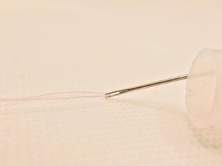 Needle and thread isolated on a minimal white background with copy space. Sewing instrument, tool, fabric and kit for hobby collection. Tailoring equipment. Tailor sing template. Design fashion icon.