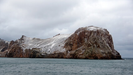 Snow dusted mountains around the pass at the entrance to the crater bay in Deception Island, Antarctica