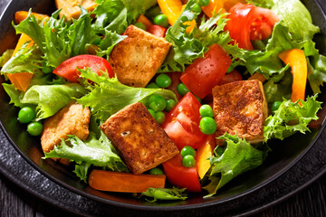 tofu salad with greens and vegetables in bowl