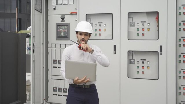 An engineer man or worker, people working in electrical room. Power energy motor machinery cabinets with panel in control or server room, operator station network in industry factory. Switchgear