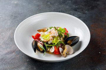 Salad with seafood and mix salad on a white plate