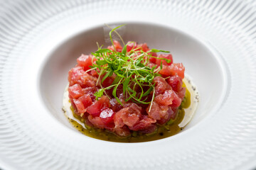 Tuna tar tar with avocado on a white plate macro close up