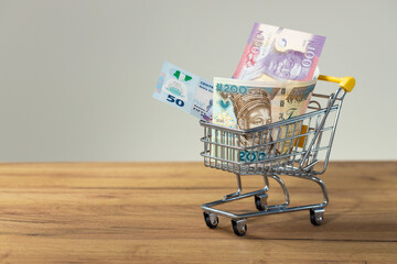 Nigerian money, shopping cart, The concept of high prices, inflation, rising prices of shopping and...