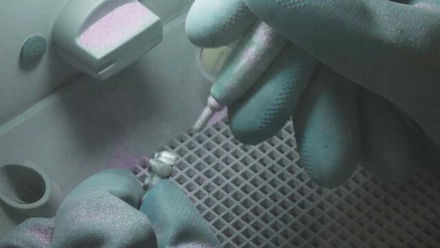 Close-up of dental sandblaster equipment spraying on artificial teeth. Dental equipment used to clean artificial teeth. Dental care equipment is removing dirt from artificial teeth bridge replacement