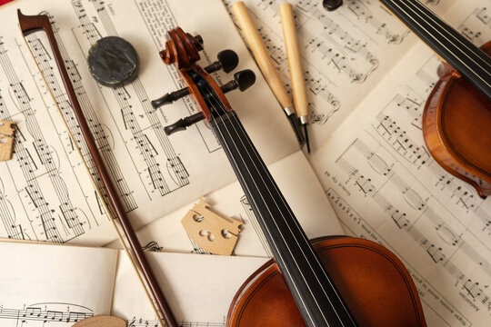 Top view of violins on top of sheet music in a workshop