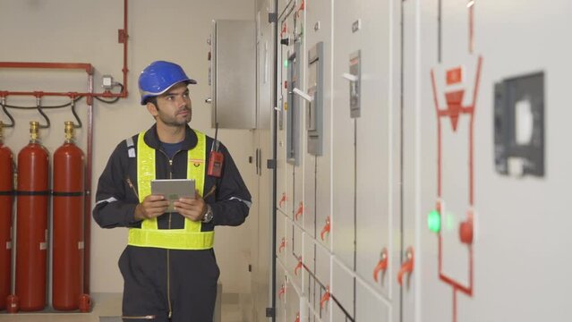 An engineer man or worker, people working in electrical room. Power energy motor machinery cabinets with panel in control or server room, operator station network in industry factory. Switchgear