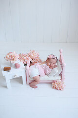 Little baby sweetly sleeping on the light background. sleeping newborn in a wrap