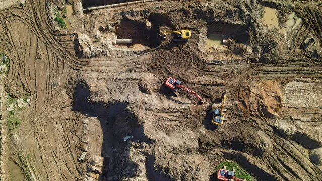 Aerial view of excavators on earthwork at construction site. Earthworks during the install of storm sewers. Installation of storm sewers and construction of a road in a new residential area.