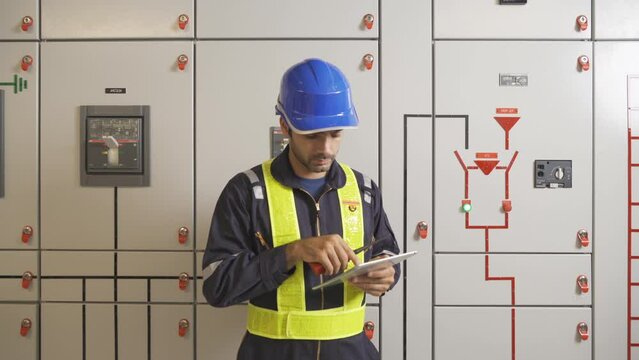 An engineer man or worker, people working in electrical room. Power energy motor machinery cabinets with panel in control or server room, operator station network in industry factory. Switchgear