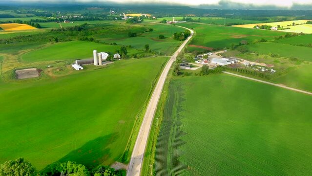 Aerial view of scenic country road with fields and farms in the American Heartland.
