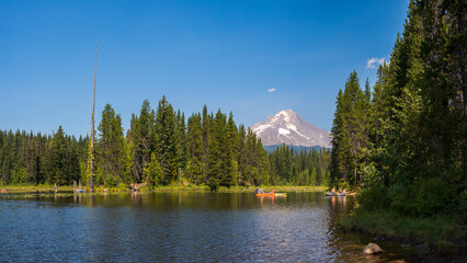 View of Mt. Hood Topped with Snow and Recreational Camping Area with Lake on Bright Sunny Day Surrounded by Wilderness