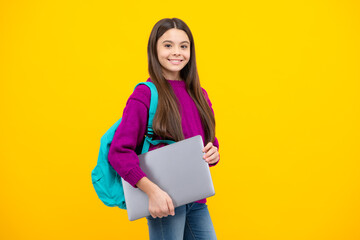 Schoolchild, teenage student girl with laptop on yellow isolated studio background. Children school and education concept.