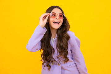 Cute school girl wearing sunglasses on yellow studio background, girl in glasses.