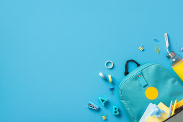 Top view photo of blue schoolbag with notepads pens and airplane shaped sharpener drink bottle...