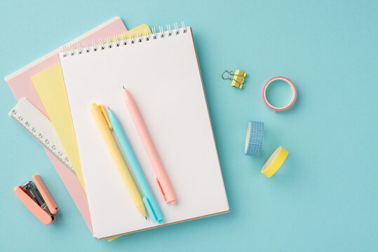 Back to school concept. Top view photo of colorful stationery planners pens ruler adhesive tape binder clip and mini stapler on isolated pastel blue background
