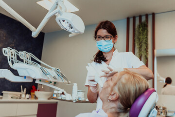 A dentist in a modern dental practice performs jaw surgery on an elderly patient