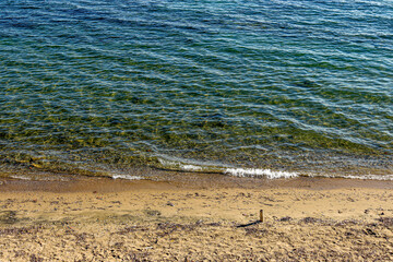 Sea waves breaking on the beach with sand and pebbles