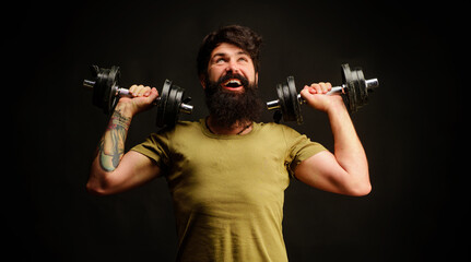 Fototapeta na wymiar Sporty handsome man lifting dumbbells at gym. Strong athletic guy. Strength and motivation. Fitness.