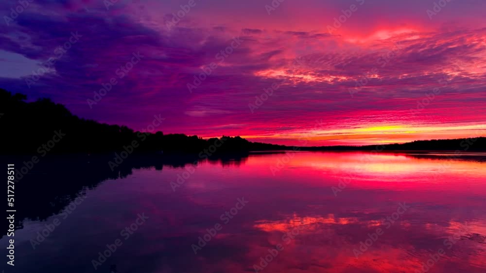 Wall mural amazing red sky mirrored in still waters at dawn, dynamic moving perspective.