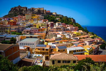 view of the city of Castelsardo, Sassari, Sardegna. Colorful houses on the hill with the sea behind. Castle on top. - obrazy, fototapety, plakaty