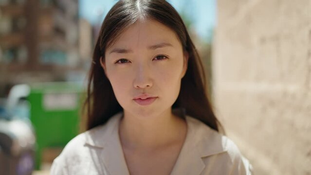 Chinese woman with relaxed expression standing at street