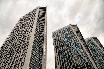 Obraz premium Panoramic and perspective bottom view of high rise steel and glass building with reflections, skyscrapers, industrial architecture. underside panoramic and perspective