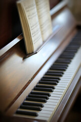 Closeup of a vintage piano and keyboard with a sheet music book. An empty antique or wooden musical...
