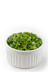 Sliced ​​scallion in ramekin isolated on white background.