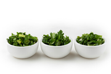 Sliced ​​cilantro, chives and parsley in ramekin.