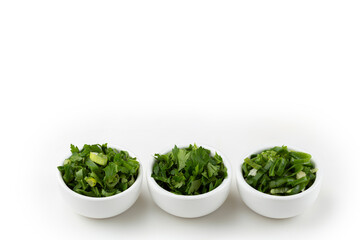 Sliced ​​cilantro, chives and parsley in ramekin.