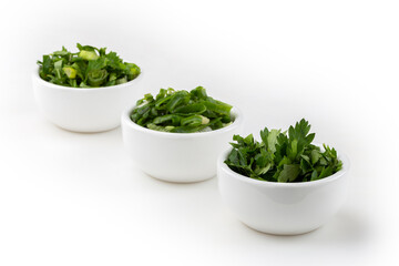 Sliced ​​cilantro, chives and parsley in ramekin.